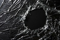 Plastic wrap with hole tear backgrounds black destruction.