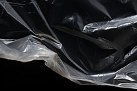 Plastic wrap with hole tear backgrounds black black background.