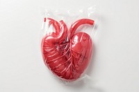 Plastic wrapping over a heart food white background confectionery.