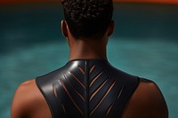 The back of a black person wearing a swimming costume adult skin outdoors.