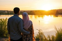 Young wealthy middle eastern couple standing outdoors sunset.