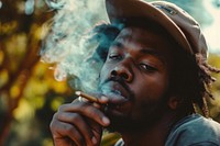 Black man smoking cannabis joint smoke contemplation relaxation.
