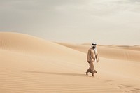 Middle Eastern Man walking desert outdoors.