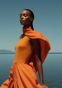 A black woman wearing orange modern minimal cloth fashion photography portrait.