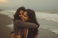 Bangladeshi lesbian couple hugging on the beach outdoors portrait smiling.