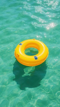 Yellow inflatable ring in the ocean outdoors summer waterfront.