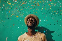 Cheerful black man with confetti enjoying laughing cheerful smile.