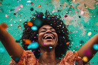 Cheerful black woman with confetti enjoying laughing cheerful celebration.