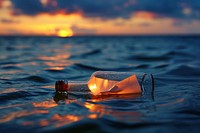 Paper role in a bottle floating on water outdoors nature light.