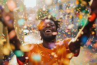 Cheerful black man with confetti enjoying cheerful adult vibrant color.