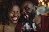 Happy black couple celebrating embracing laughing drinking.