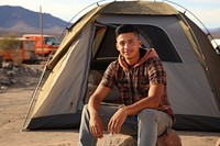 Young Mexican man outdoors camping tent.