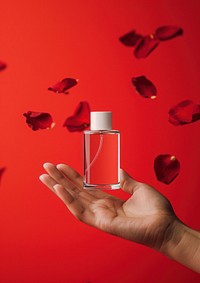 Perfume glasses bottle  holding petal hand.