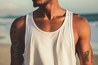Man wearing white tank top tattoo beach back.