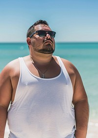 Fat man wearing white tank top glasses summer beach.