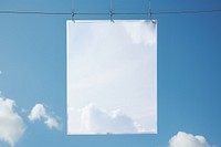 White a0 vertical poster on wire mesh sky outdoors blue clothesline.