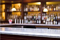Classic bar counter with empty bottles in blurred background drink refreshment illuminated.