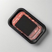 Sealable black plastic tray and cover with raw meat schnitzels and blank label  packaging gray background electronics technology.