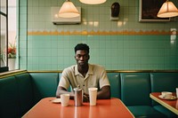 Black man sitting restaurant coffee.