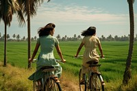 Two chinese women field outdoors bicycle.