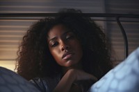 The black woman is sitting on the side of bed portrait worried adult.