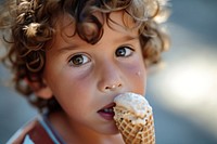 Boy eating ice cream cone dessert child food.