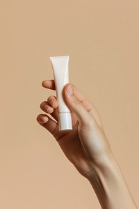 Squeezing cream from a tube cosmetics holding hand.