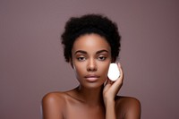 Cleansing her face skin with a cotton pad portrait cosmetics adult.