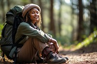 Middle age african american woman backpacker sitting travel forest.