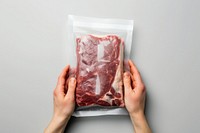 Close-up hand carry choose beef plastic package and cover with blank label meat food pork.