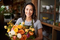 Woman in apron holding a bouquet of flowers smile store plant.