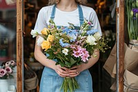 Woman in apron holding a bouquet of flowers plant store entrepreneur.