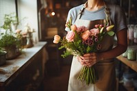 Woman in apron holding a bouquet of flowers plant adult woman.