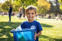 Kids volunteer holding recycling basket smile plant grass.