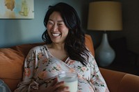 Pregnant asian woman drinking portrait smiling.