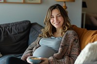 Pregnant british woman smiling sitting anticipation.