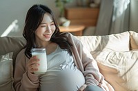 Pregnant korean woman drink drinking sitting.