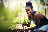 Black woman planting garden gardening outdoors.