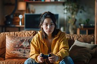 Woman holding a game controller furniture sitting adult. AI generated Image by rawpixel.