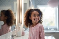 Mixed race girl bathroom mirror smile.