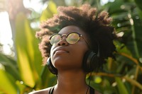 Black teen woman listening music headphones sunglasses portrait.