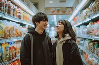 Photo of Japanese young adult couple supermarket shopping happy.