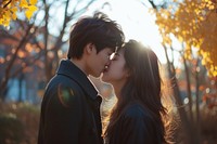 Photo of korean young adult couple kissing portrait outdoors plant.