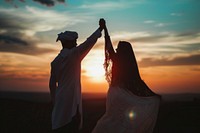 Middle eastern couple dancing outdoors sunset nature.