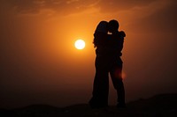 Silhouette Middle Eastern hugging backlighting outdoors sunset.