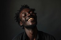 Black man laughing adult eyes closed.