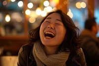 Korean woman laughing adult eyes closed.