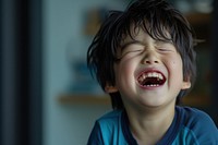 Young japanese boy laughing baby eyes closed.