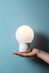 Small lamp lightbulb holding hand.
