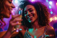 Carefree young woman with drink dancing by female friend enjoying at nightclub carefree laughing party.